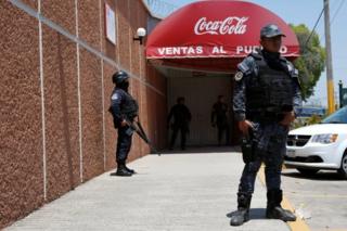 Police officers guard the entrance of the Coca-Cola FEMSA distribution plant after it closes down due to the issues of security and violence during the campaign rally of Independent presidential candidate Margarita Zavala (unseen) in Ciudad Altamirano in Guerrero state, Mexico April 3, 2018.