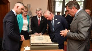 Prince Charles inspects the Great Book of Ireland at University College Cork