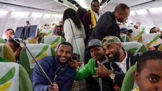 Passengers pose for a selfie picture inside an Ethiopian Airlines flight who departed from the Bole International Airport in Addis Ababa, Ethiopia, to Eritrea