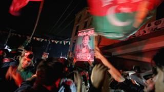 Supporters of Imran Khan, chairman of the Pakistan Tehreek-e-Insaf political party, celebrate near his residence in Bani Gala during the general election, in Islamabad
