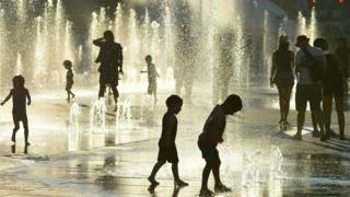 Children play in the water fountains at the Place des Arts in Montreal, Canada on a hot summer day July 3, 2018.