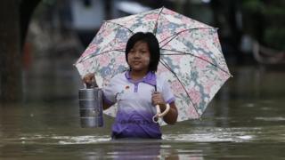 Woman wading through flooded street