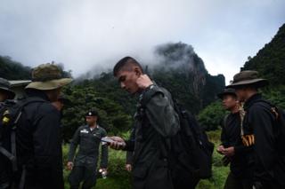 Thai soldiers and police gather in the mountains near the Tham Luang cave