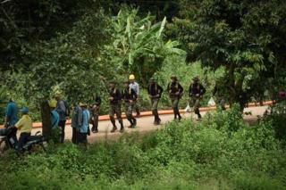 Thai soldiers run down the road leading to the Tham Luang cave