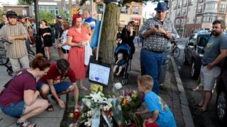 Mourners leave flowers at a memorial for the victims of a mass shooting on Danforth Avenue in Toronto