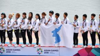 Unified Korea team sing together with unified flag