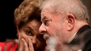 Former Brazilian President Luiz Inacio Lula da Silva speaks with former Brazilian President Dilma Rousseff during the inauguration of the new National Directory of the Workers