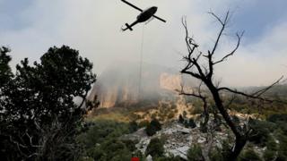 Helicopter crews tackle the Ferguson Fire as it burns along El Portal Road, a key entryway into Yosemite Valley, on Aug 13, 2018