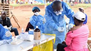 A Congolese health worker administers Ebola vaccine to a woman who had contact with an Ebola sufferer in the village of Mangina in North Kivu