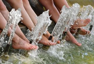 Tourists refresh their feet in a pool during a heatwave in Montpellier