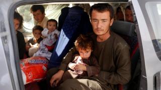 An Afghan family, who have escaped from the volatile city of Ghazni province, poses for a photograph in the entrance gate of Kabul, Afghanistan, 13 August 2018.