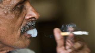 An Indian man smokes a cigarette in New Delhi.