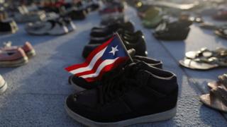 A Puerto Rican flag is seen on a pair of shoes among hundreds displayed at the Capitol