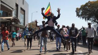 Supporters of the opposition Movement for Democratic Change party (MDC) of Nelson Chamisa, sing and dance as they march in the streets of Harare, 1 August 2018