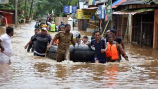 Rescuers evacuate people from a flooded area to a safer place in Aluva - 18 August
