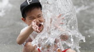 A South Korean child cools off in a fountain in Gwanghwamun square in Seoul, South Korea, 24 July 2018