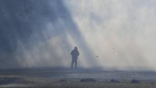 A firefighter stands in the middle of smoke from a bushfire near Nowra in New South Wales