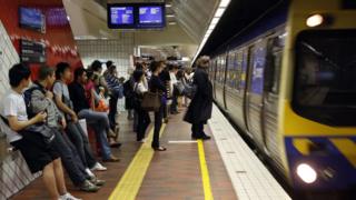 Passengers wait on a platform at Melbourne Central train station