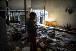 The Ethiopian owner of a looted grocery store in Soweto, Johannesburg, stands in his ransacked shop