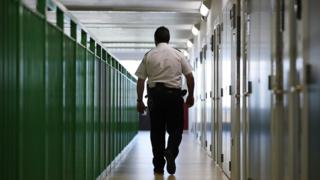 A prison guard walks along a corridor in HMP Berwyn