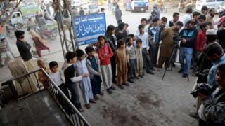 Pakistani youth and onlookers gather at the spot where Nasiruddin Haqqani, a senior leader of the feared militant Haqqani network, was assassinated outside the Afghan bakery in the Bhara Kahu area on the outskirts of Islamabad on November 11, 2013.