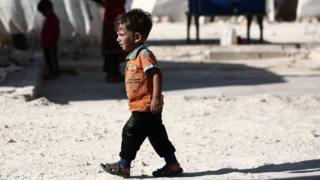 A Syrian child walks in front of tents at a camp for displaced people in Idlib province (2 September 2018)