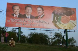 A Pakistani man sits under a welcoming billboard ahead of a visit by Chinese President Xi Jinping in Islamabad on April 17, 2015.