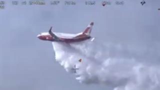 The Coulson Aviation 737 Fireliner Airtanker drops water over a bushfire in New South Wales