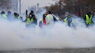 Protesters stand in smoke from police grenades in Paris on 1 December 2018