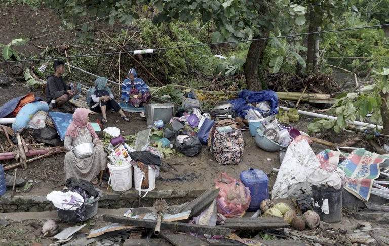 epa07246138 Indonesian residents gather near their house after a tsunami hit Sunda Strait in Anyer, Banten, Indonesia, 23 December 2018. According to the Indonesian National Board for Disaster Management (BNPB), at least 43 people dead and 584 others have been injured after a tsunami hit the coastal regions of the Sunda Strait. EPA/DIAN TRIYULI HANDOKO