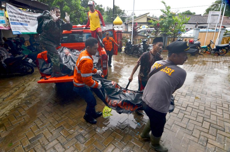 Rescuers carry body bags of victims to a makeshift mortuary in Carita on December 23, 2018, after the area was hit by a tsunami on December 22 following an eruption of the Anak Krakatoa volcano. - A tsunami following a volcanic eruption killed 62 people and injured hundreds more as it slammed without warning into tourist beaches and coastal areas around Indonesia's Sunda Strait on the night of December 22, sending panicked holidaymakers and residents fleeing. (Photo by Ronald / AFP)RONALD/AFP/Getty Images